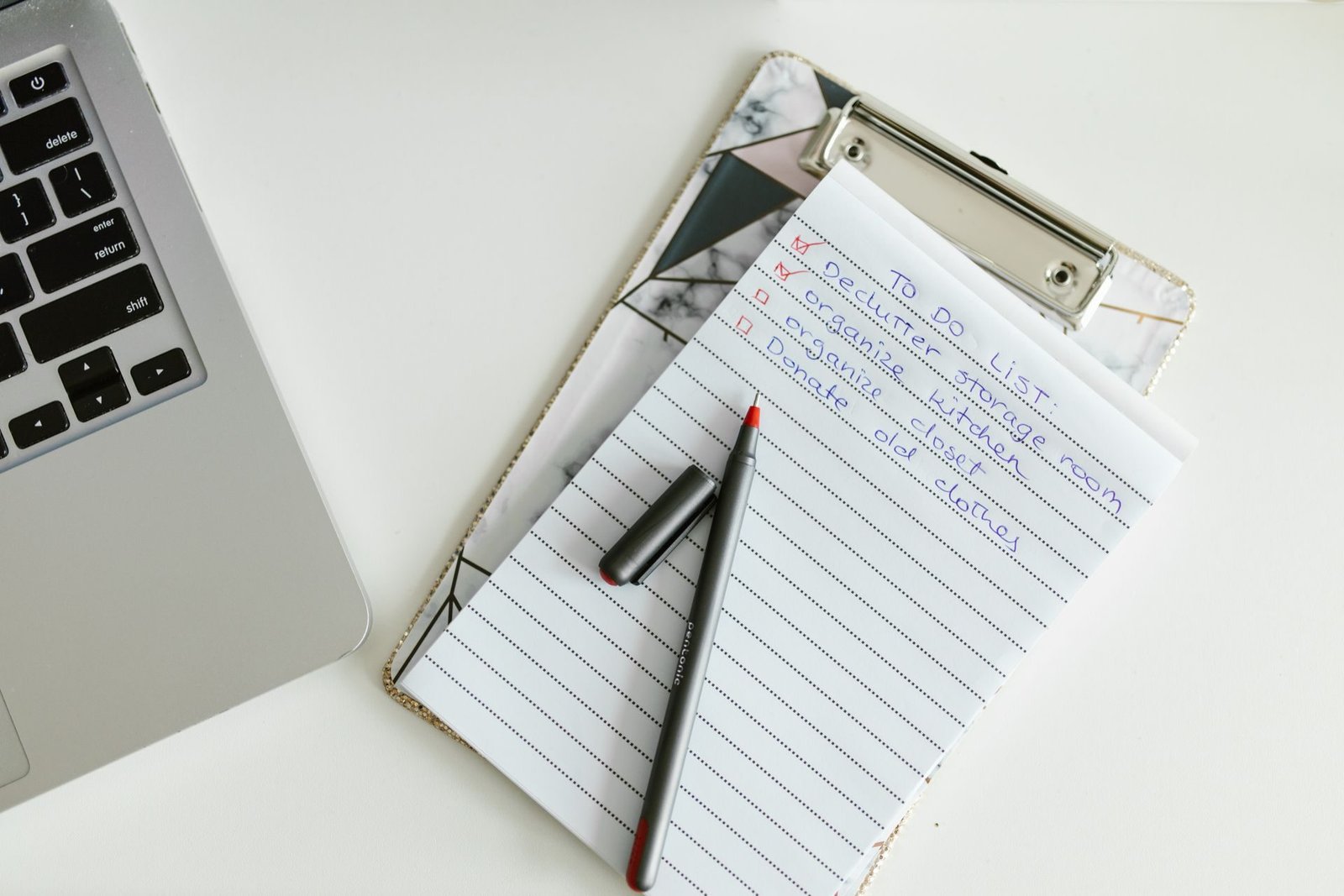 An inspection checklist on a clipboard beside a laptop