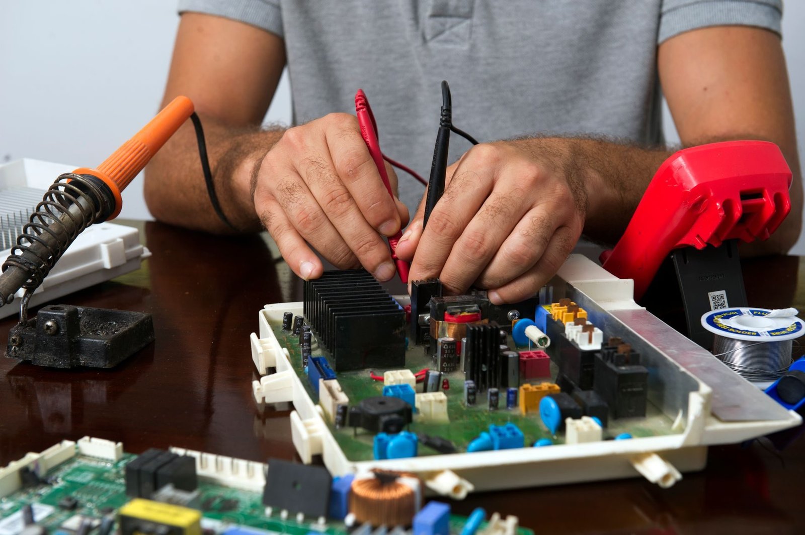 Gloved hands working on electronic equipment with tools