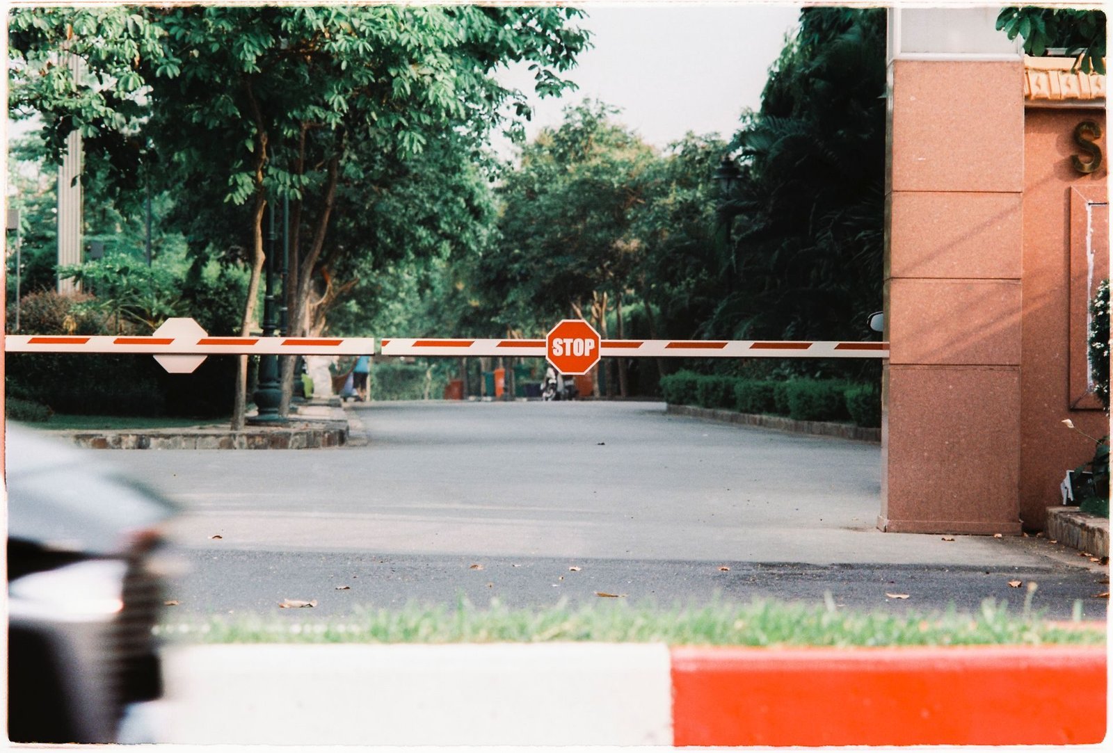 A red and white boom barrier across a parking entrance