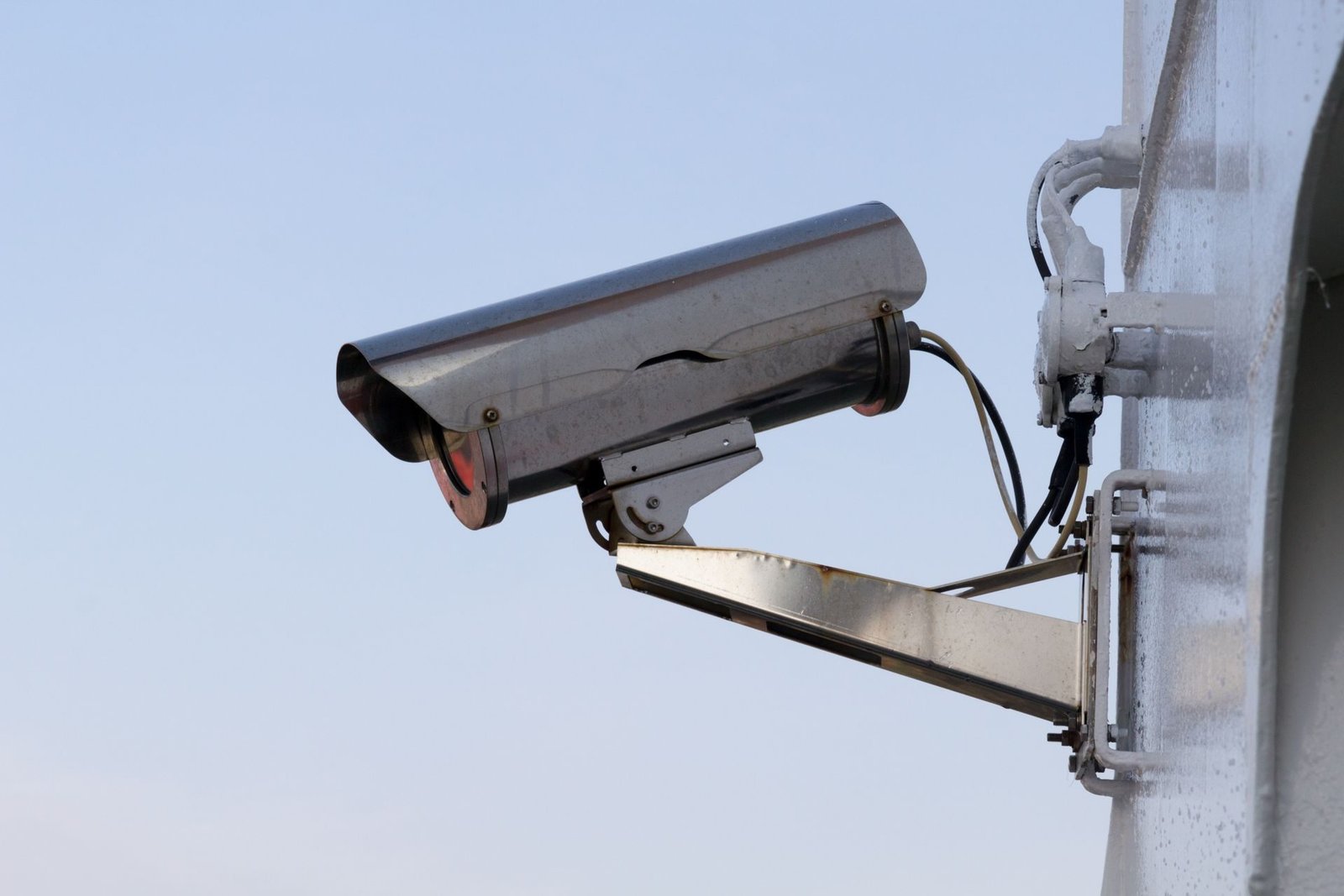 A box security camera in a housing mounted on a wall