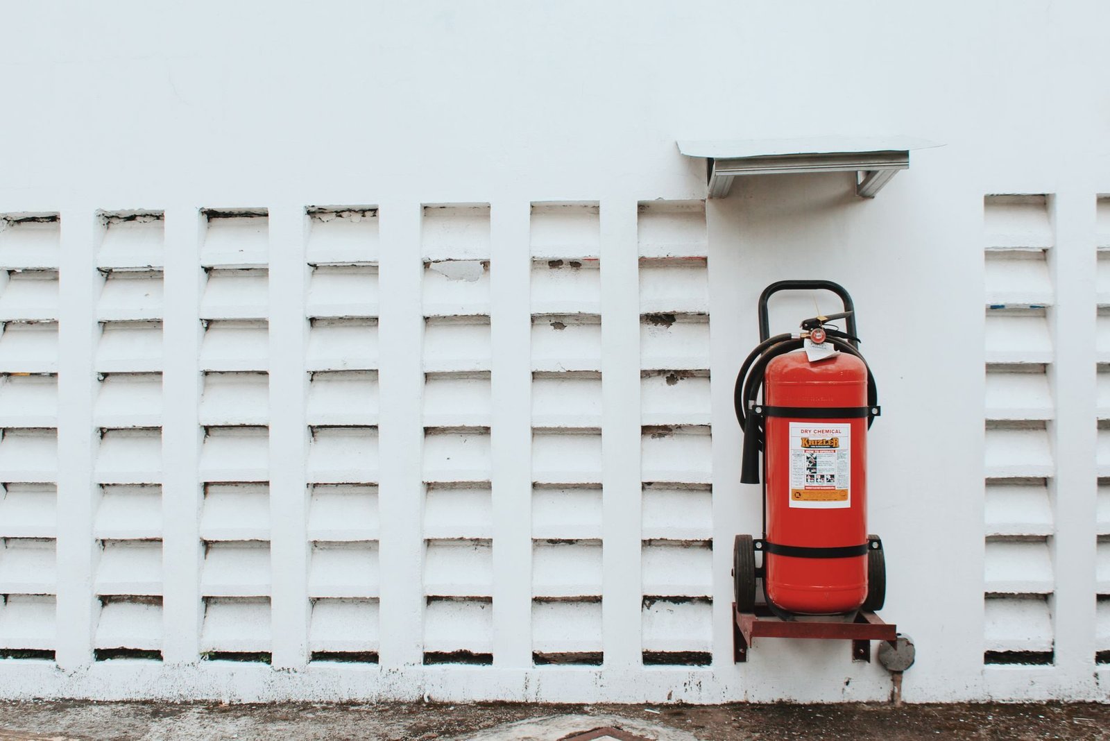 A white building facade with fire safety equipment