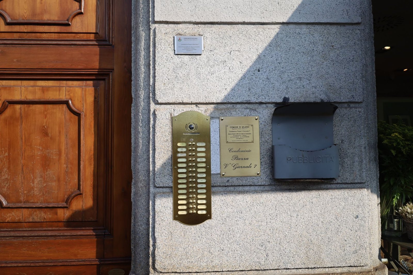 An apartment building intercom panel with call buttons