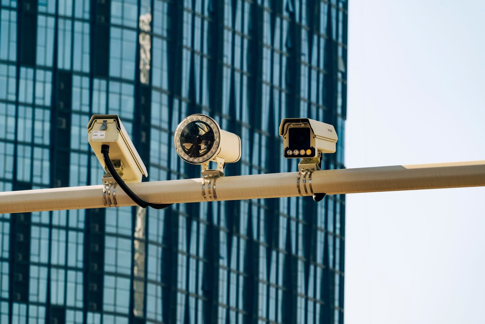 Bullet IP cameras on a pole in front of a glass office building