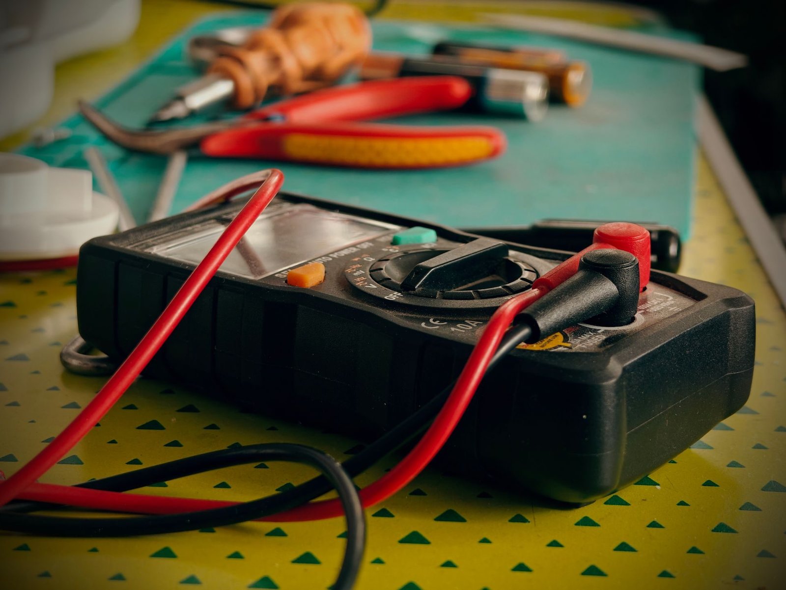 A multimeter with test leads on an electronic circuit board