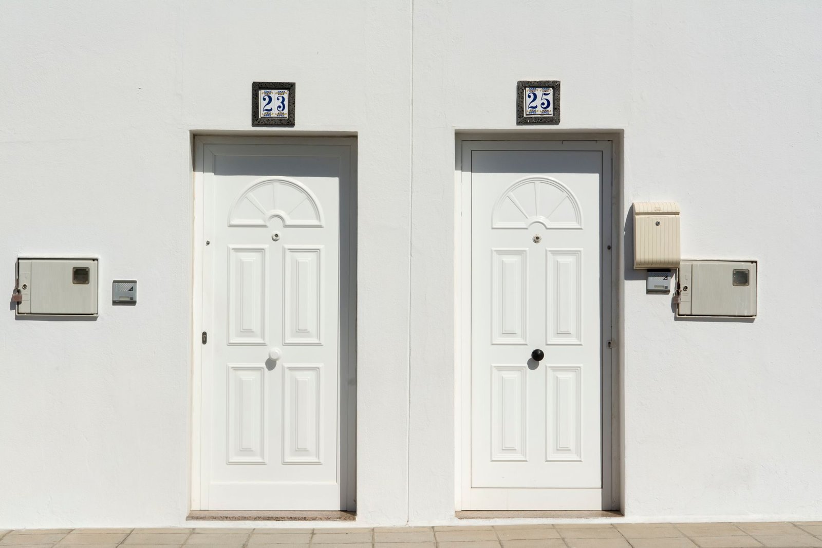 Two apartment front doors, each with a door phone panel beside it
